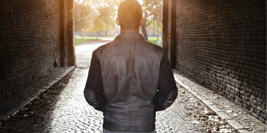 man looking at light at end of tunnel